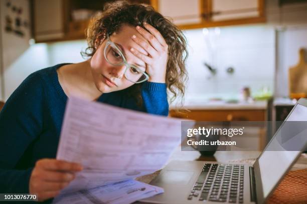 A worried condo owner looking at bills and financial documents, representing financial stress.