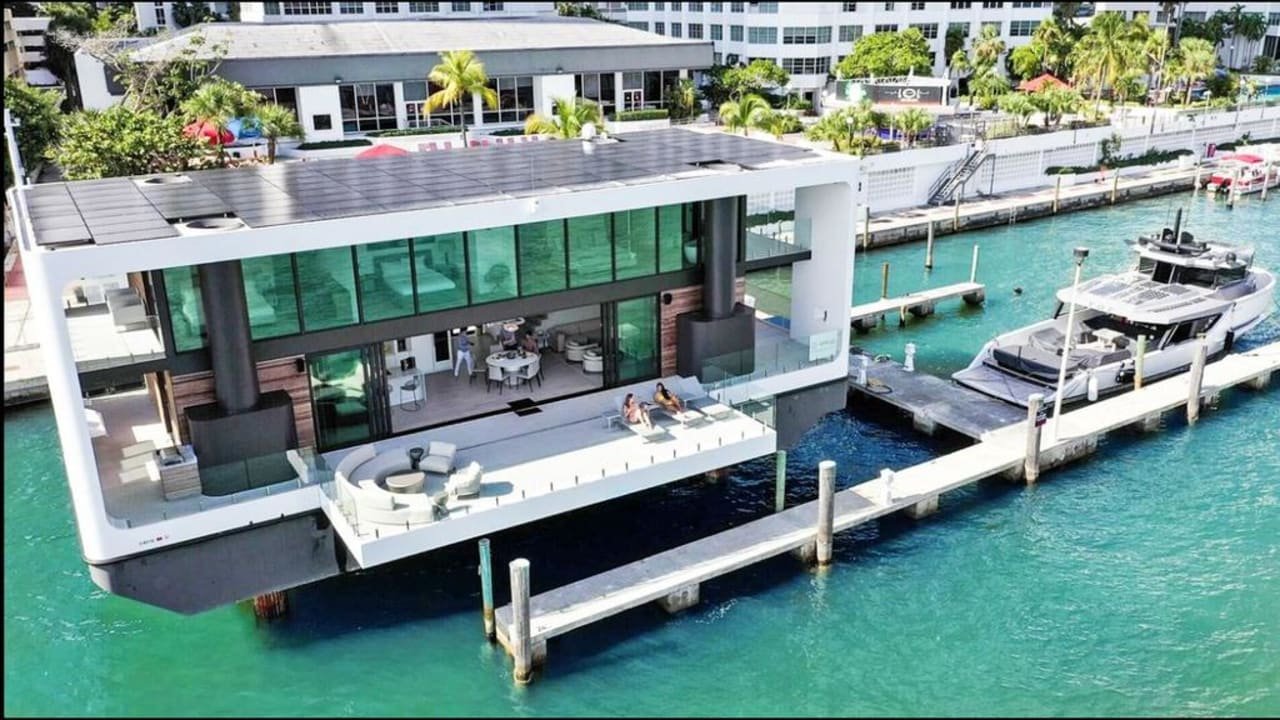 A luxury yacht docked at a private mansion dock in Miami Beach, representing the billionaire lifestyle and waterfront access