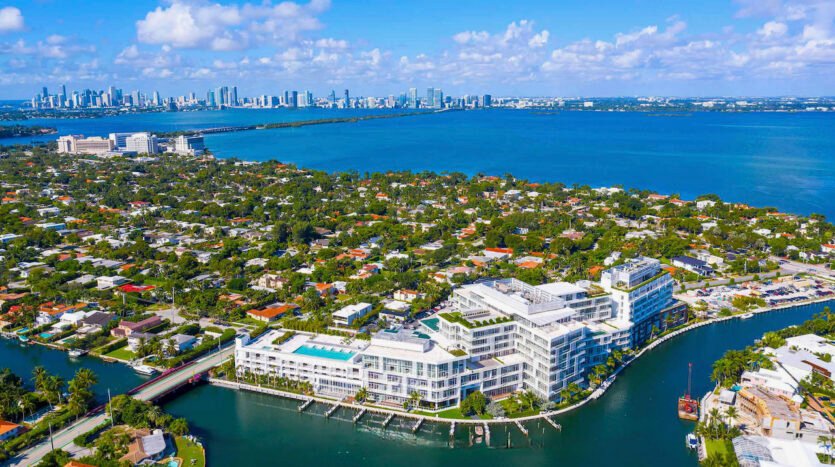 Aerial view of luxury waterfront buildings and lush neighborhoods in Miami, South Florida, with the city skyline and ocean.