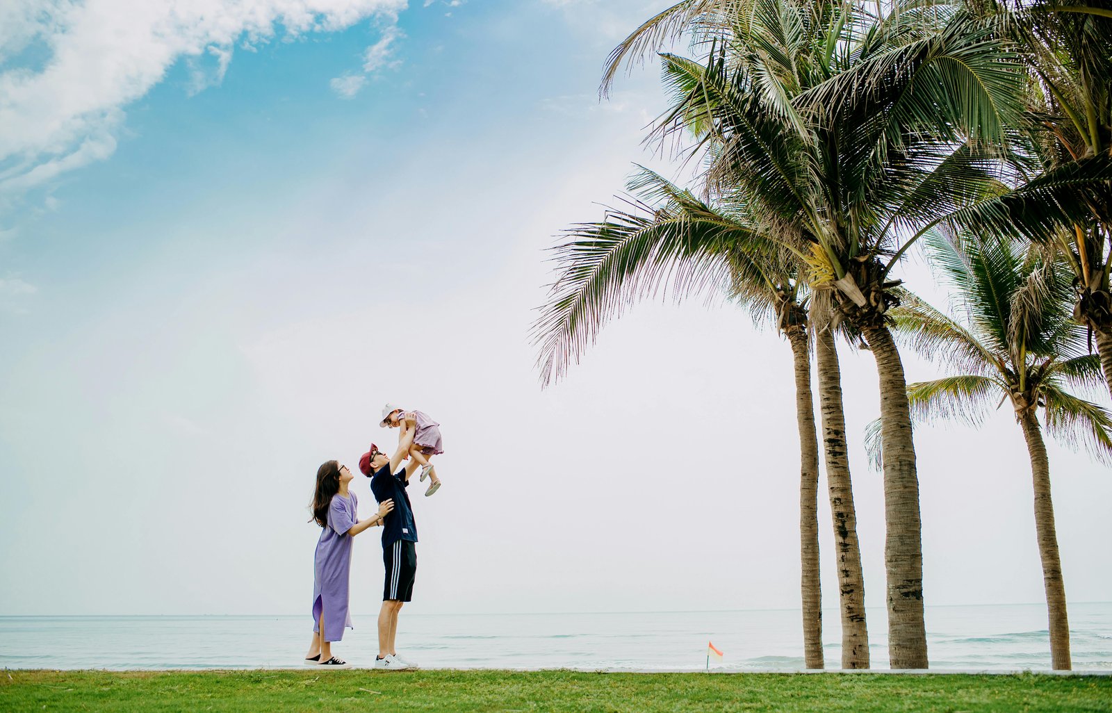 Young family enjoying outdoor activities by the waterfront in Miami with palm trees