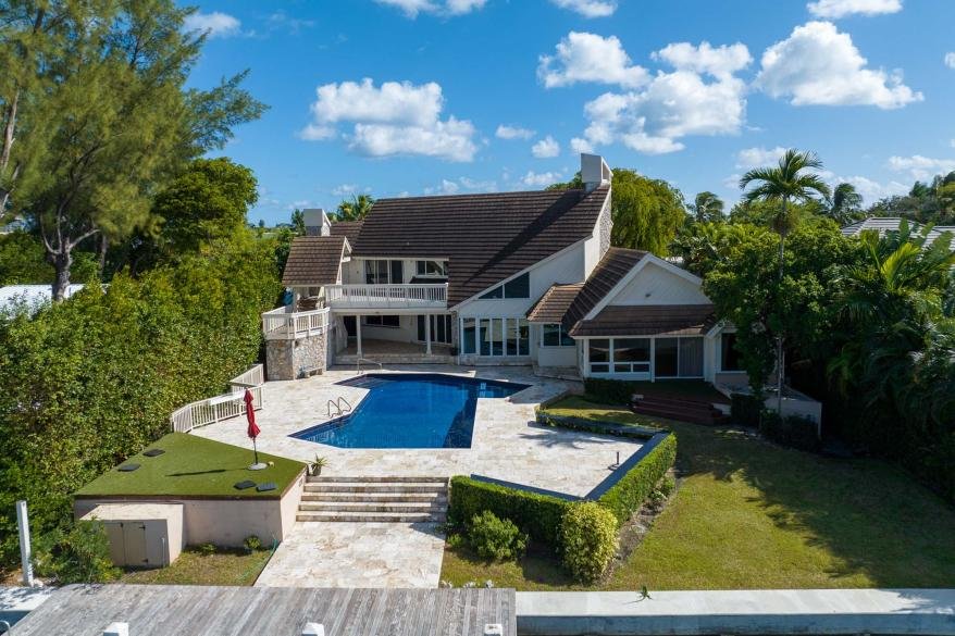 Aerial view of a Surfside waterfront home with pool and dock